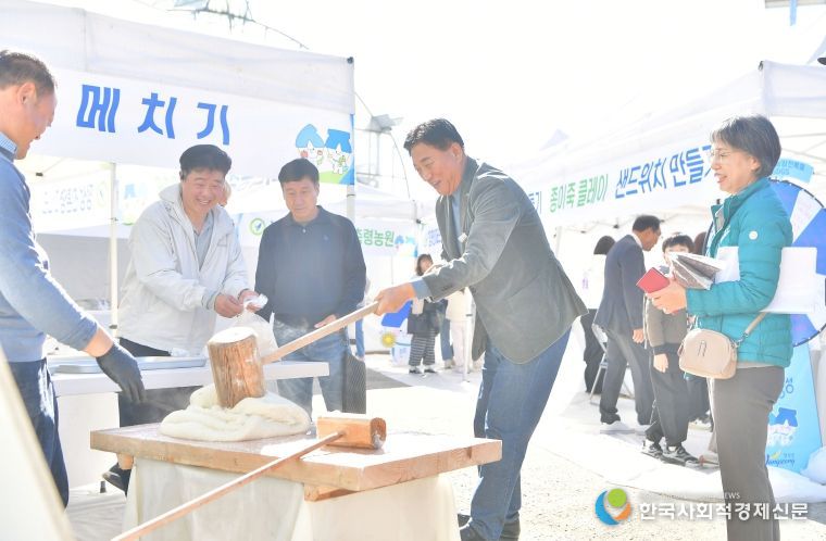 지난 15일 황룡면 팜파티 현장을 방문한 김한종 장성군수가 떡메치기 체험을 하고 있다.